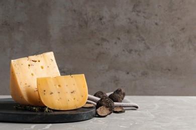 Fresh cheese and truffles on grey table, space for text