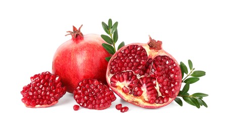 Photo of Fresh pomegranates and branches isolated on white