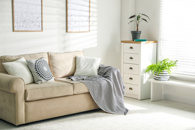 Photo of Stylish decorative pillows on beige couch indoors