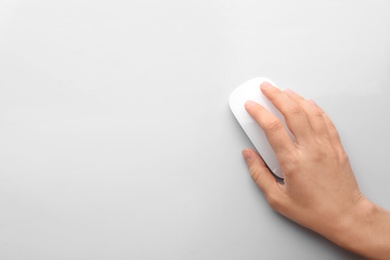 Photo of Woman using computer mouse on white background, top view. Space for text