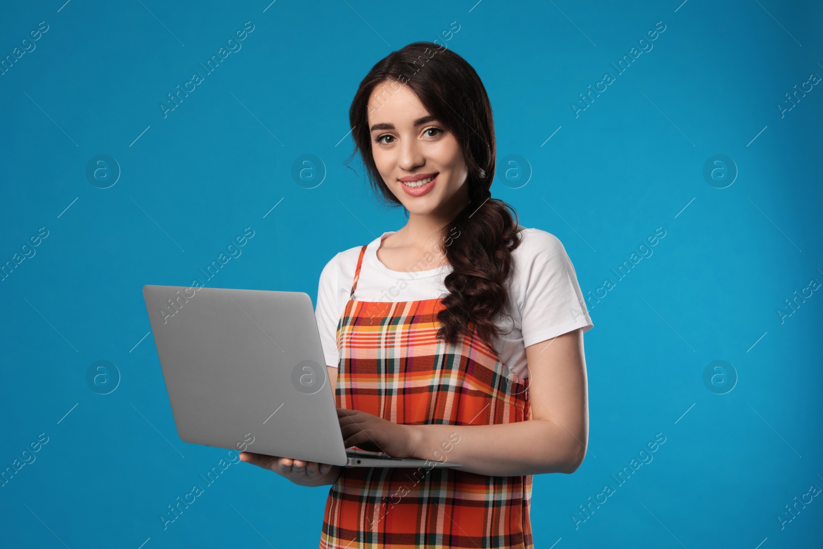 Photo of Young woman with laptop on blue background
