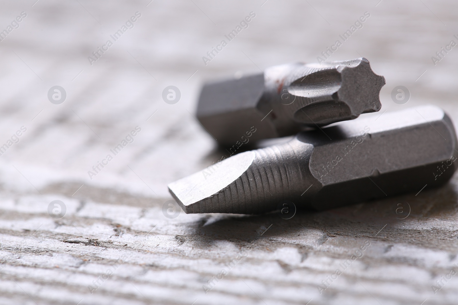 Photo of Different screwdriver bits on wooden table, closeup