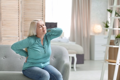 Photo of Senior woman suffering from back pain at home