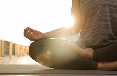 Photo of Woman practicing yoga on floor against window, closeup. Space for text