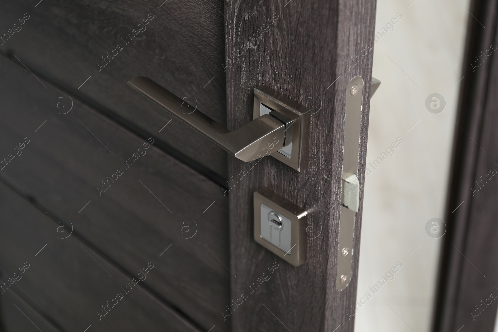 Photo of Open wooden door with metal handle, closeup