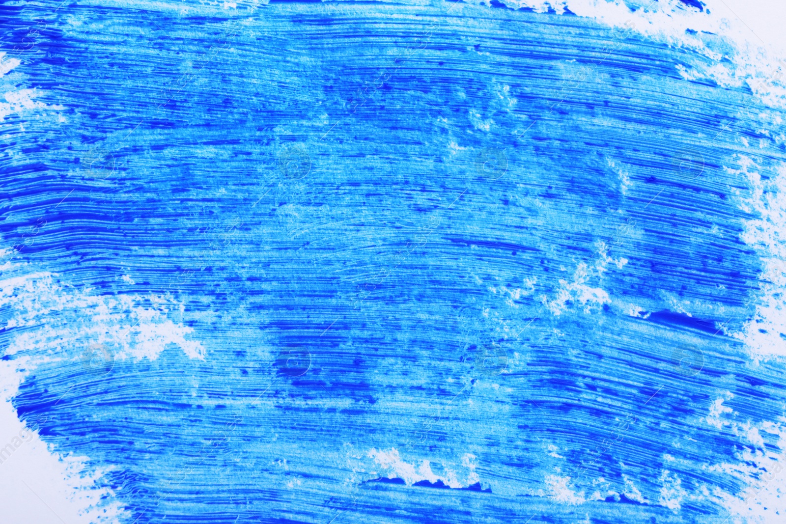 Photo of Strokes of blue mascara for eyelashes on white surface, closeup