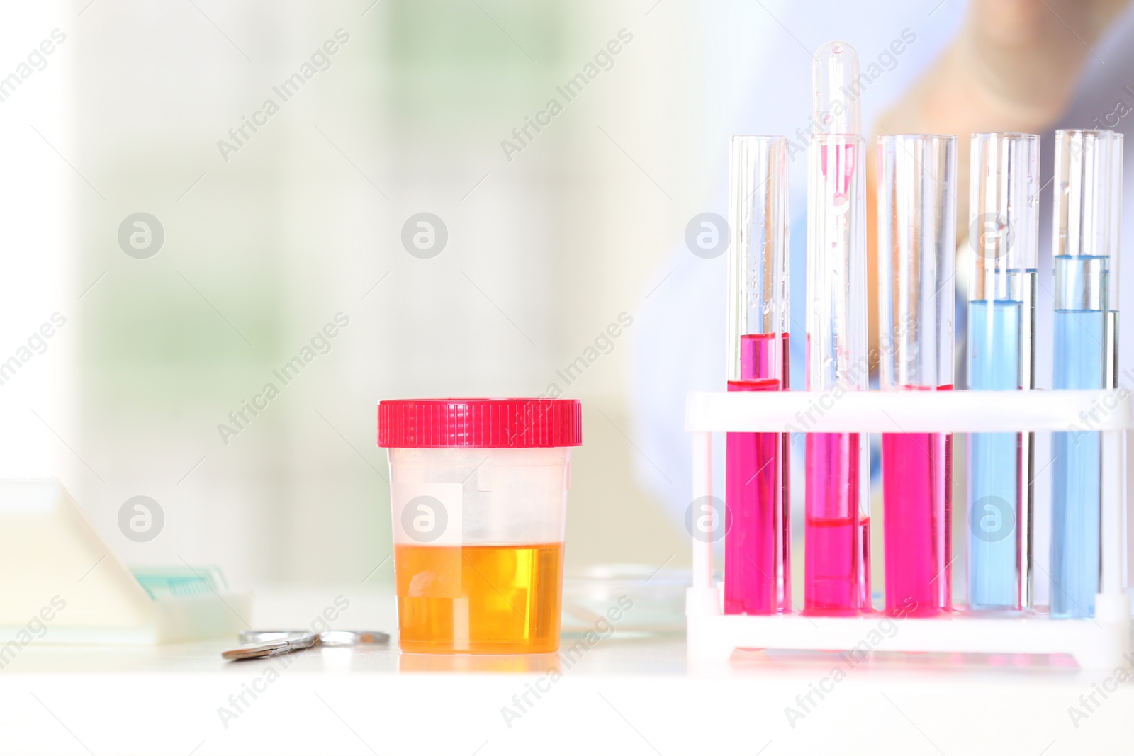 Photo of Rack with test tubes and jar on table in laboratory. Research and analysis