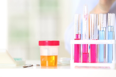 Photo of Rack with test tubes and jar on table in laboratory. Research and analysis