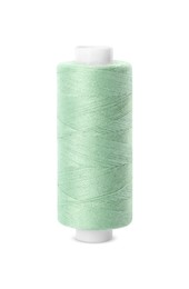 Photo of Spool of light green sewing thread isolated on white