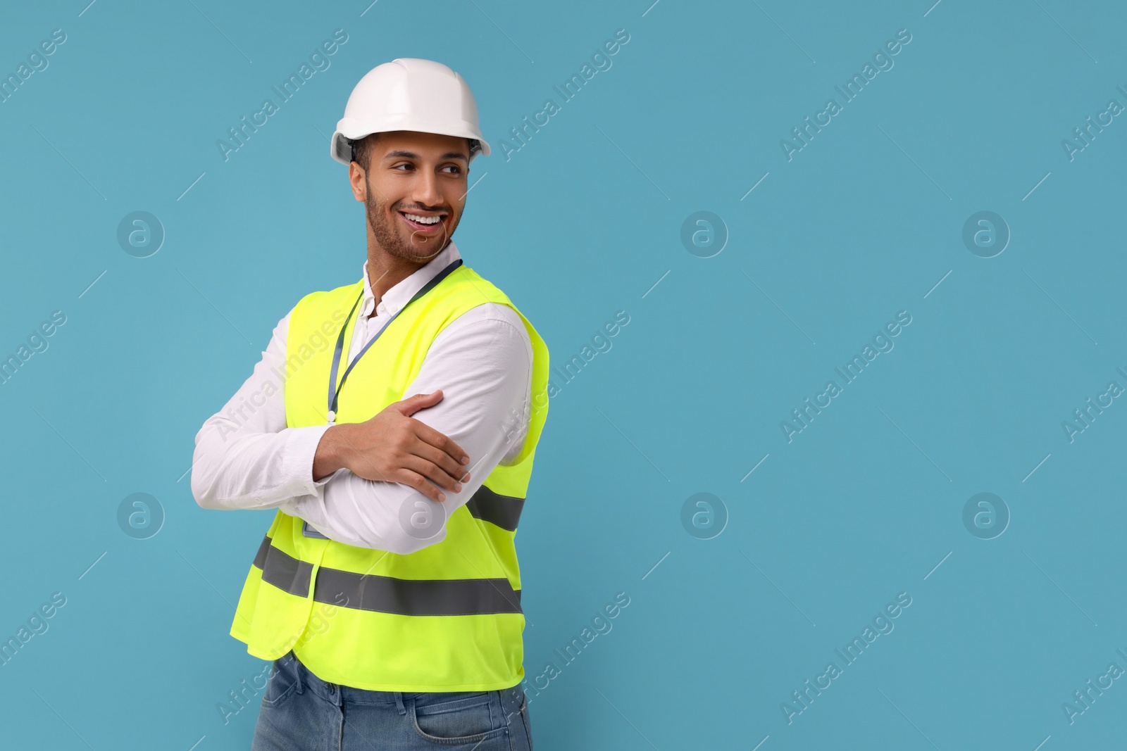 Photo of Engineer in hard hat on light blue background, space for text