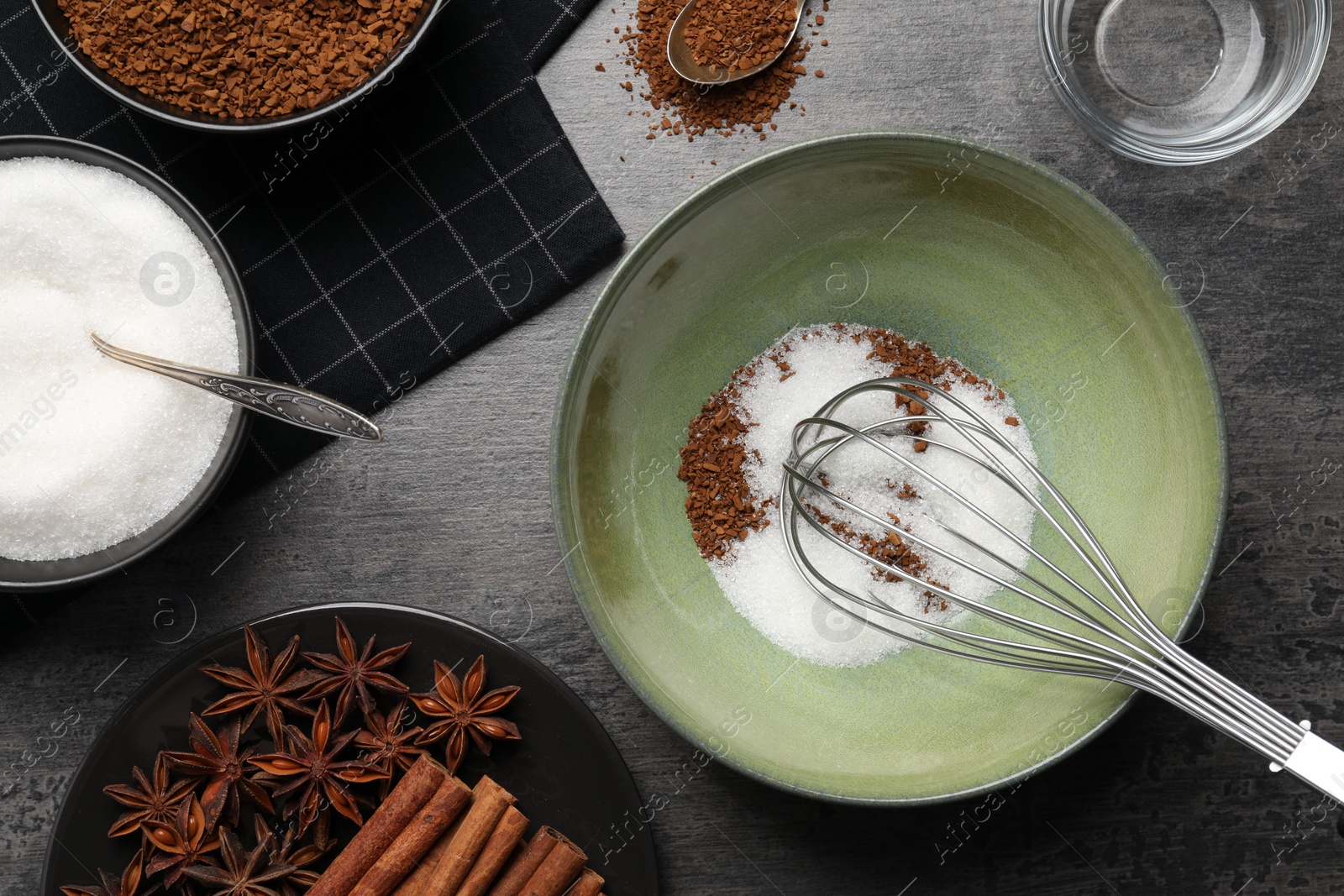 Photo of Making dalgona coffee. Instant granules, sugar, cinnamon sticks, anise stars and whisk on table, flat lay