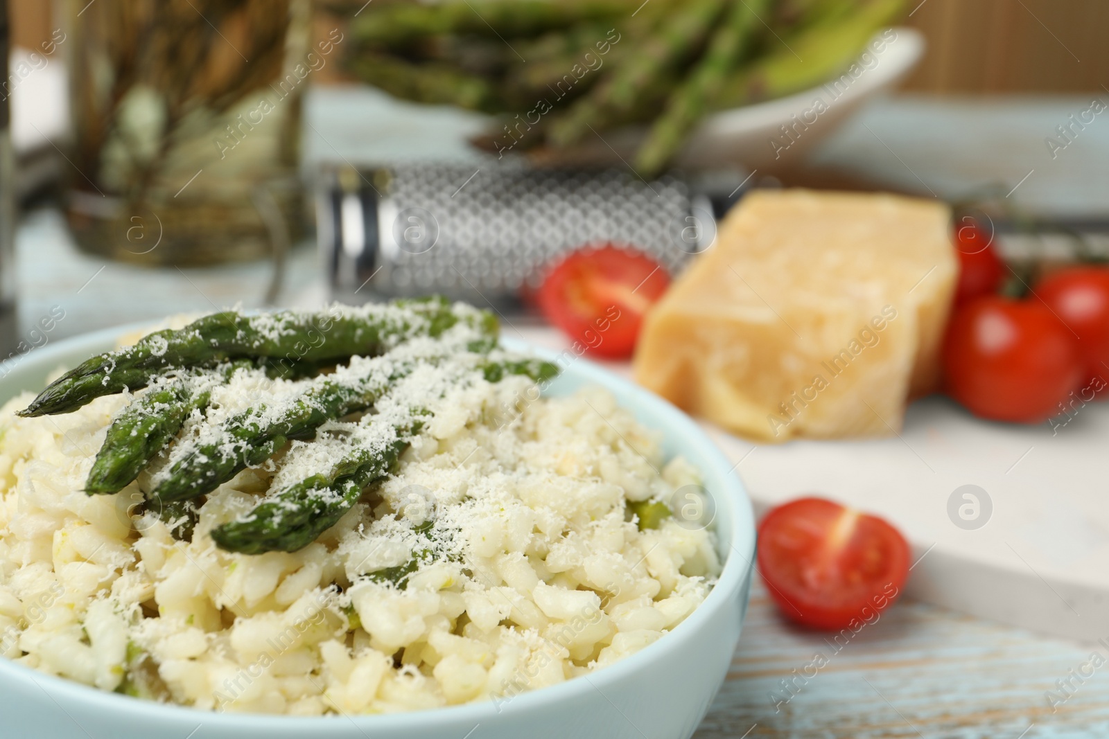 Photo of Delicious risotto with asparagus and cheese in bowl, closeup
