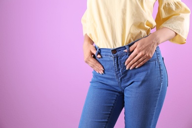 Photo of Woman in stylish blue jeans on color background