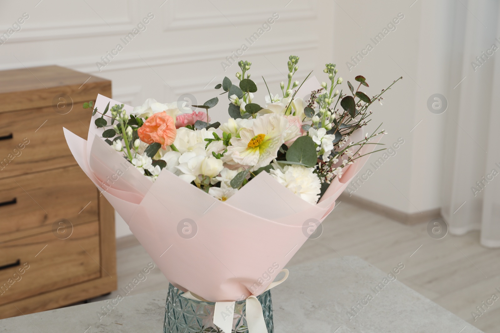 Photo of Bouquet of beautiful flowers on light grey table indoors