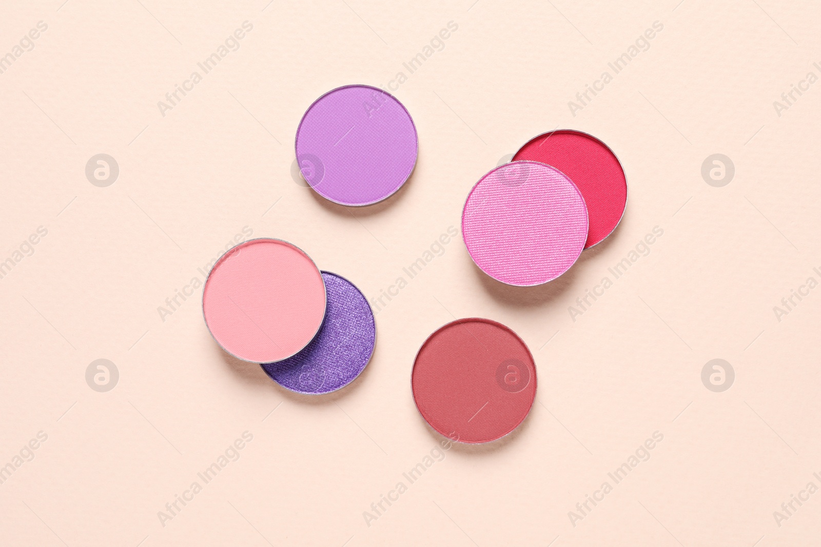 Photo of Different beautiful eye shadows on beige background, flat lay