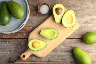 Flat lay composition with ripe avocados on wooden background