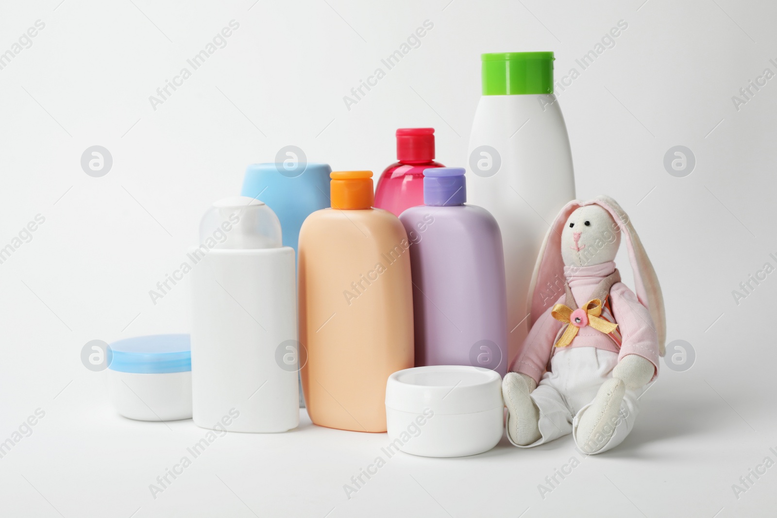 Photo of Baby cosmetic products and toy on white background