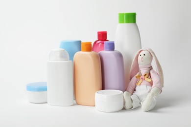 Baby cosmetic products and toy on white background