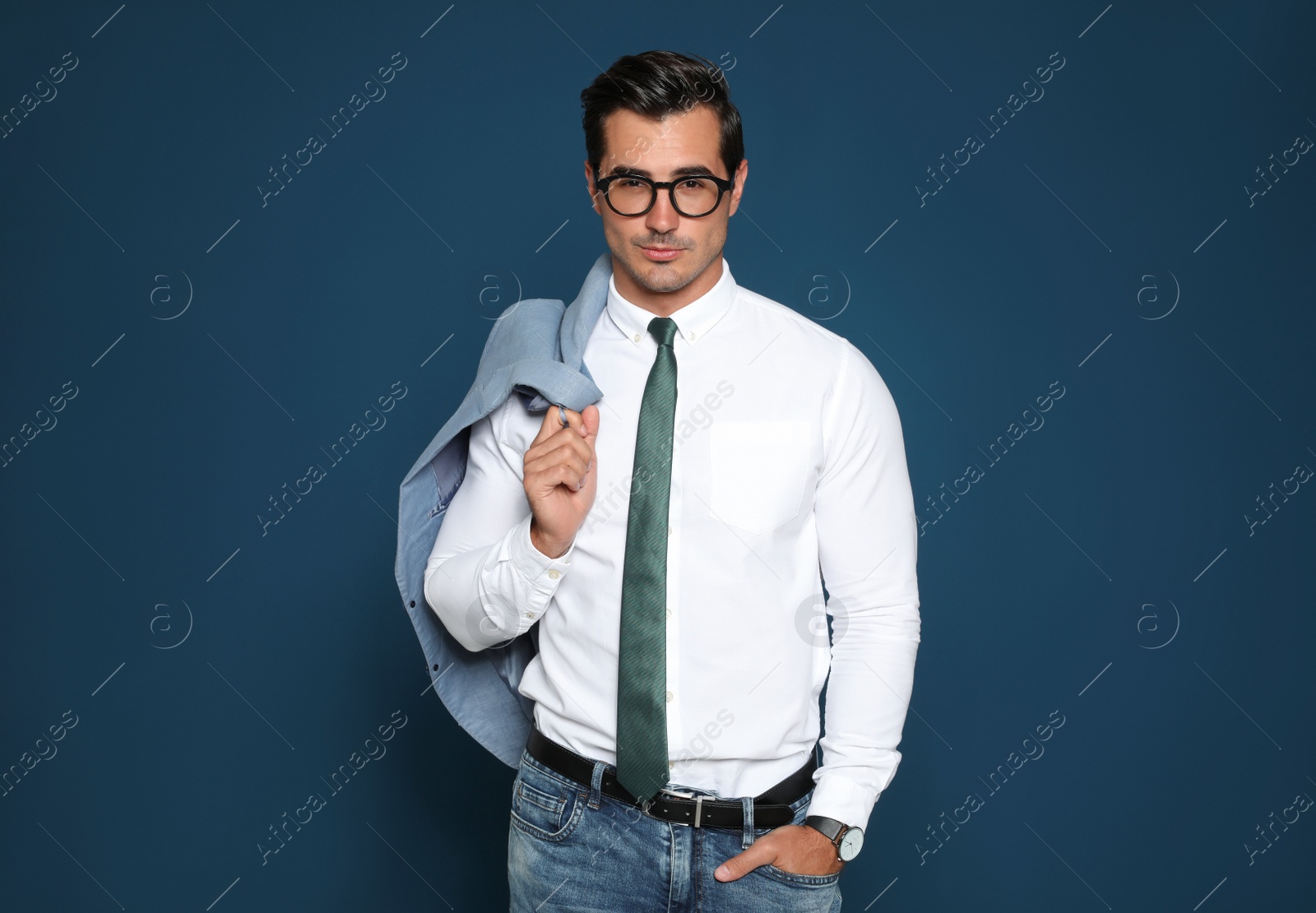 Photo of Portrait of handsome young businessman wearing glasses on blue background