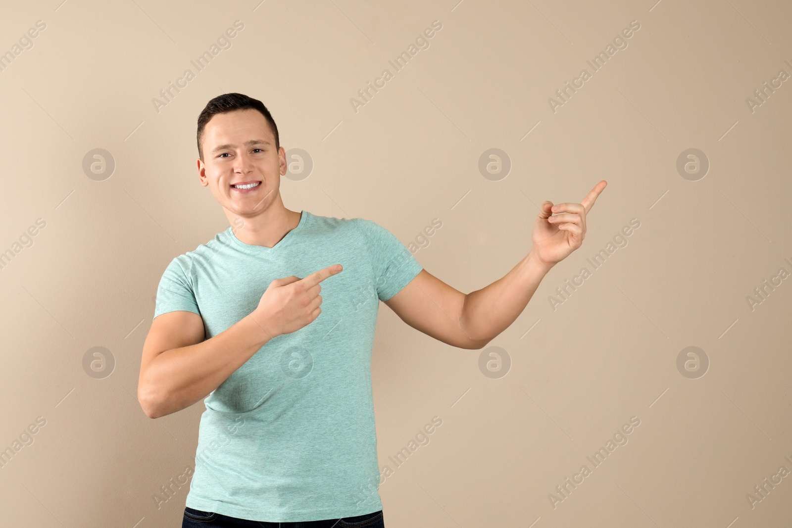 Photo of Confident handsome young man on beige background