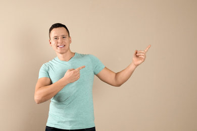 Confident handsome young man on beige background