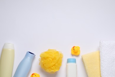 Baby cosmetic products, bath ducks, sponge and towels on white background, flat lay. Space for text