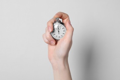 Photo of Woman holding vintage timer on light grey background, closeup