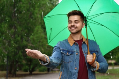 Photo of Man with umbrella outdoors on rainy day