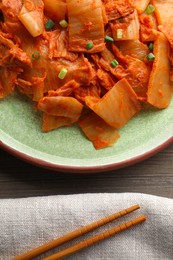 Photo of Delicious kimchi with Chinese cabbage served on wooden table, above view