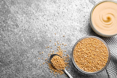 Photo of Flat lay composition with mustard seeds on grey table, space for text