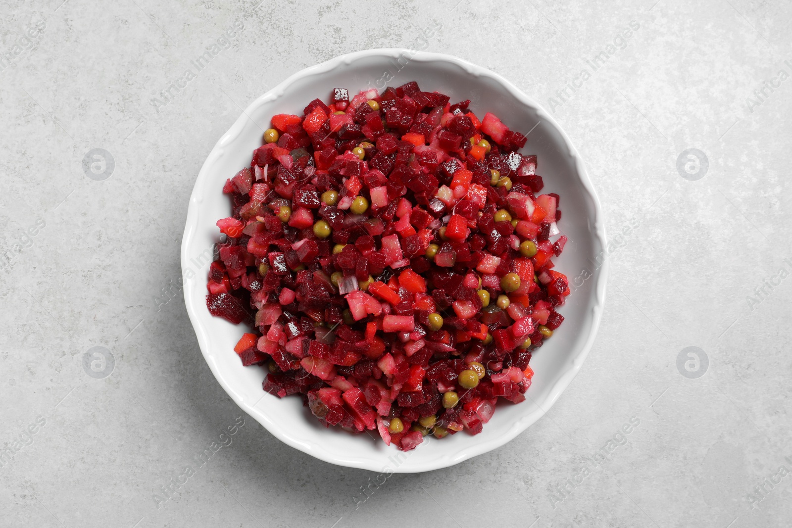 Photo of Delicious fresh vinaigrette salad on light grey table, top view