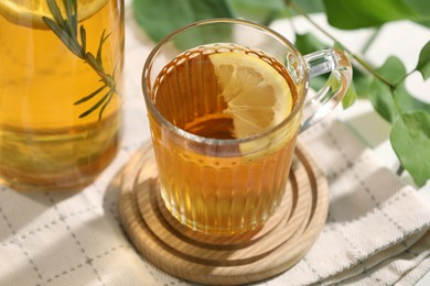 Glass cup of tasty iced tea with lemon on table, closeup