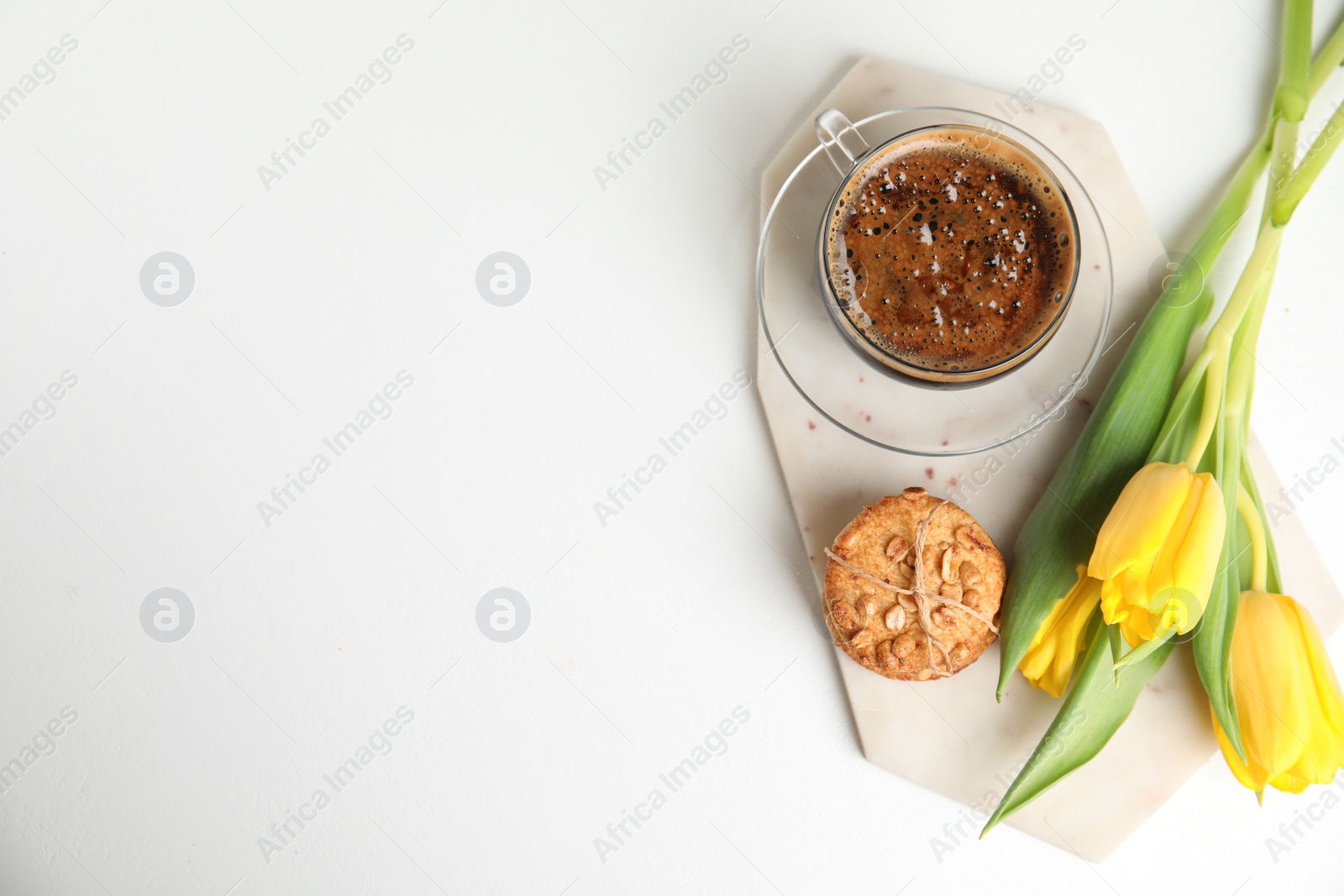 Photo of Aromatic morning coffee, cookies and beautiful flowers on white table, flat lay. Space for text