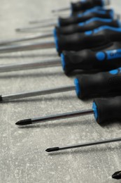 Photo of Set of screwdrivers on grey table, closeup