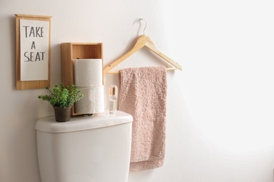 Decor elements, necessities and toilet bowl near white wall, space for text. Bathroom interior