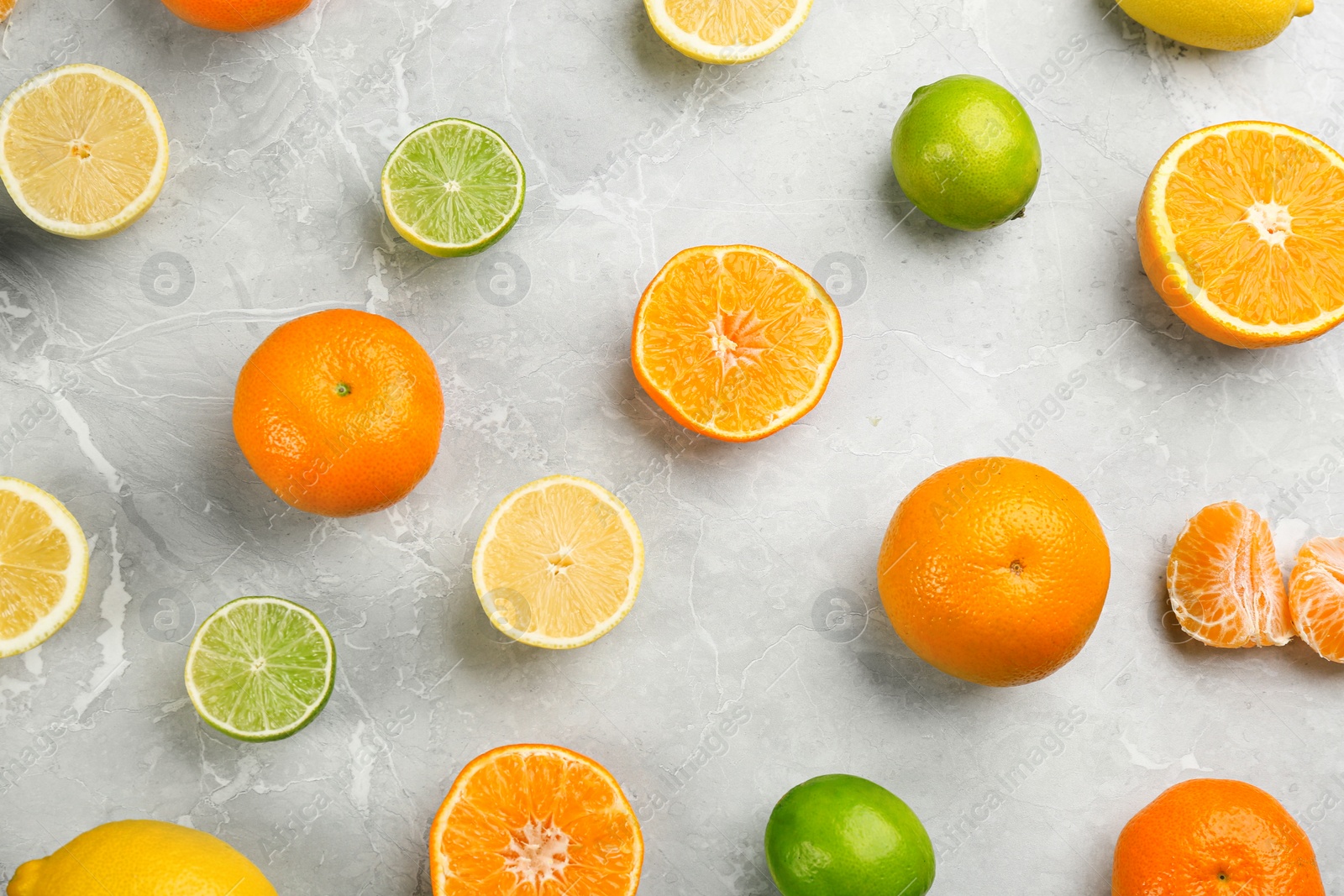 Photo of Flat lay composition with tangerines and different citrus fruits on grey marble background