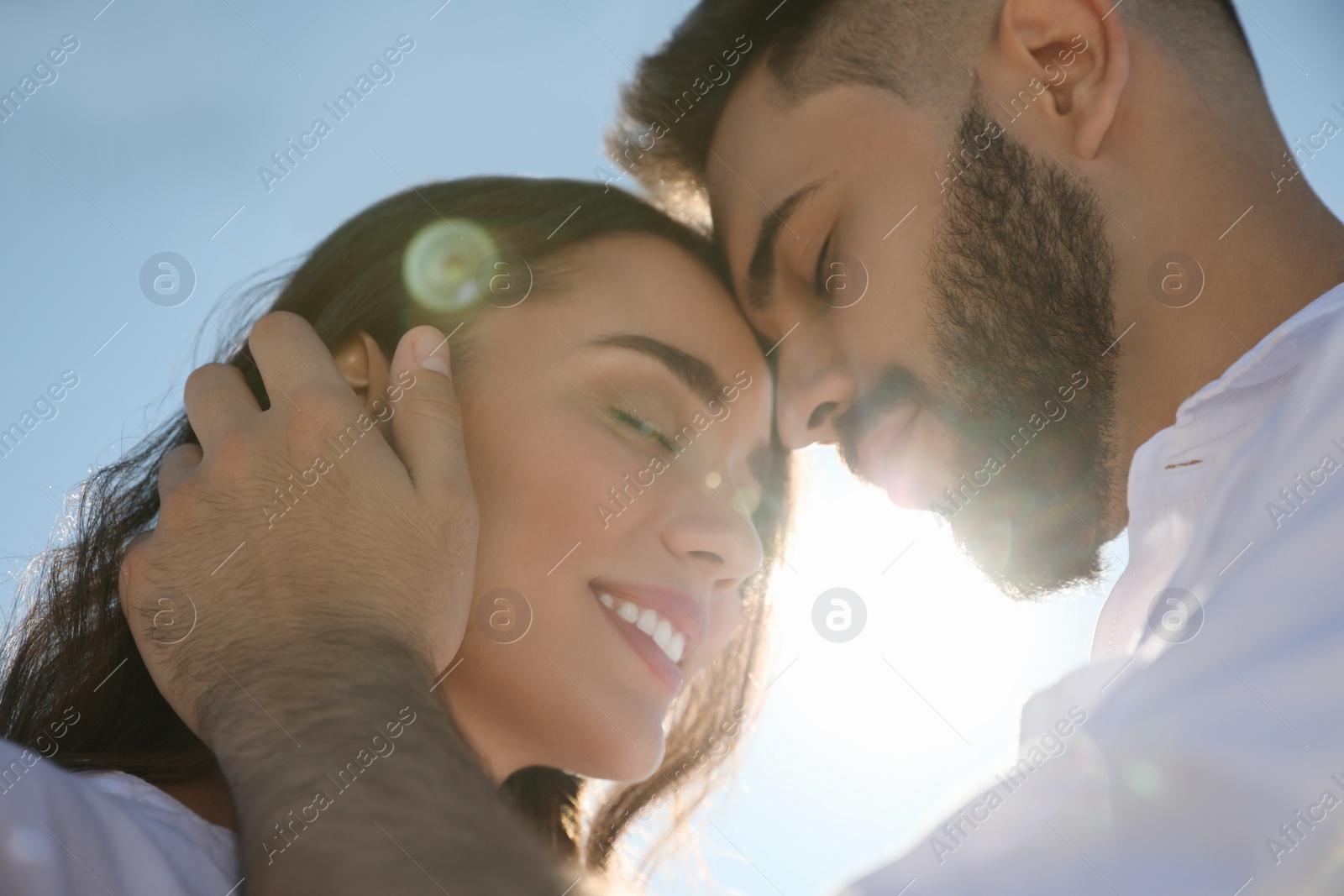 Photo of Happy young couple against blue sky, low angle view. Honeymoon trip