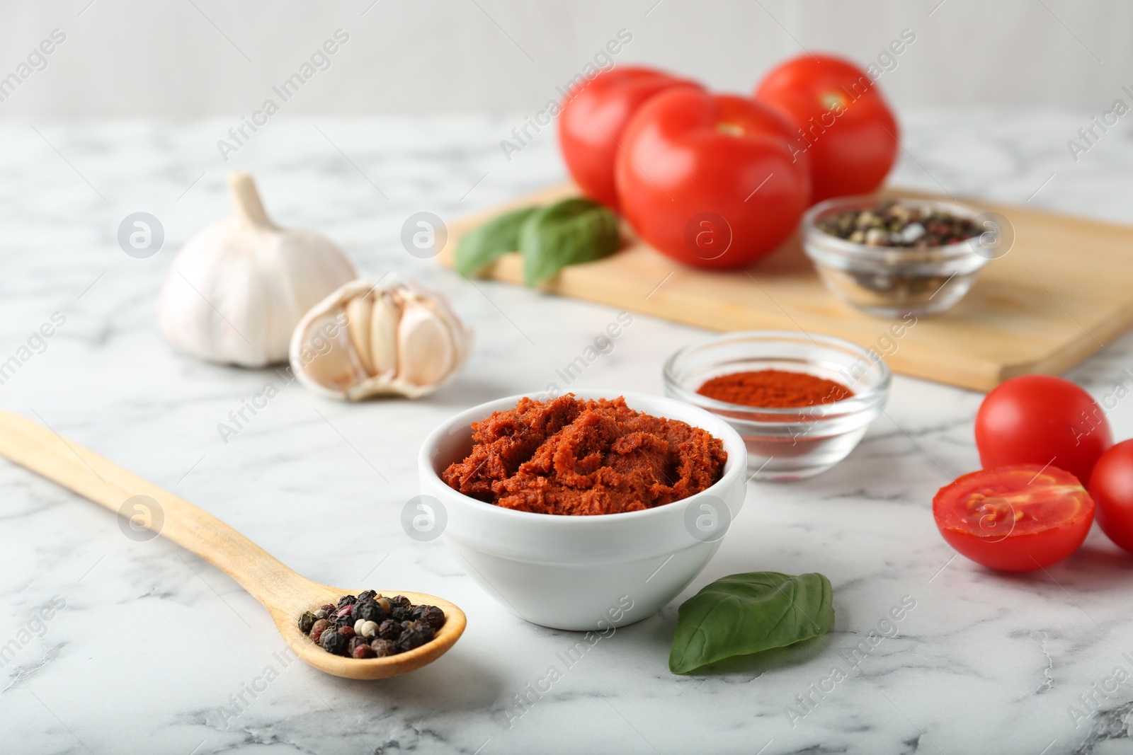 Photo of Red curry paste and ingredients on white marble table