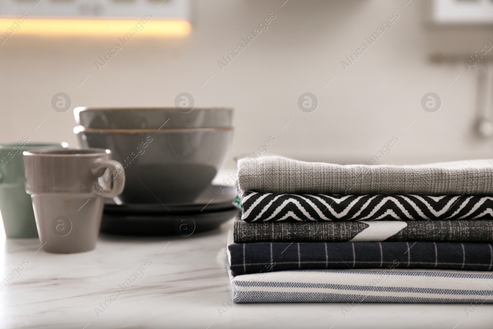 Photo of Stack of soft kitchen towels on white table indoors, space for text