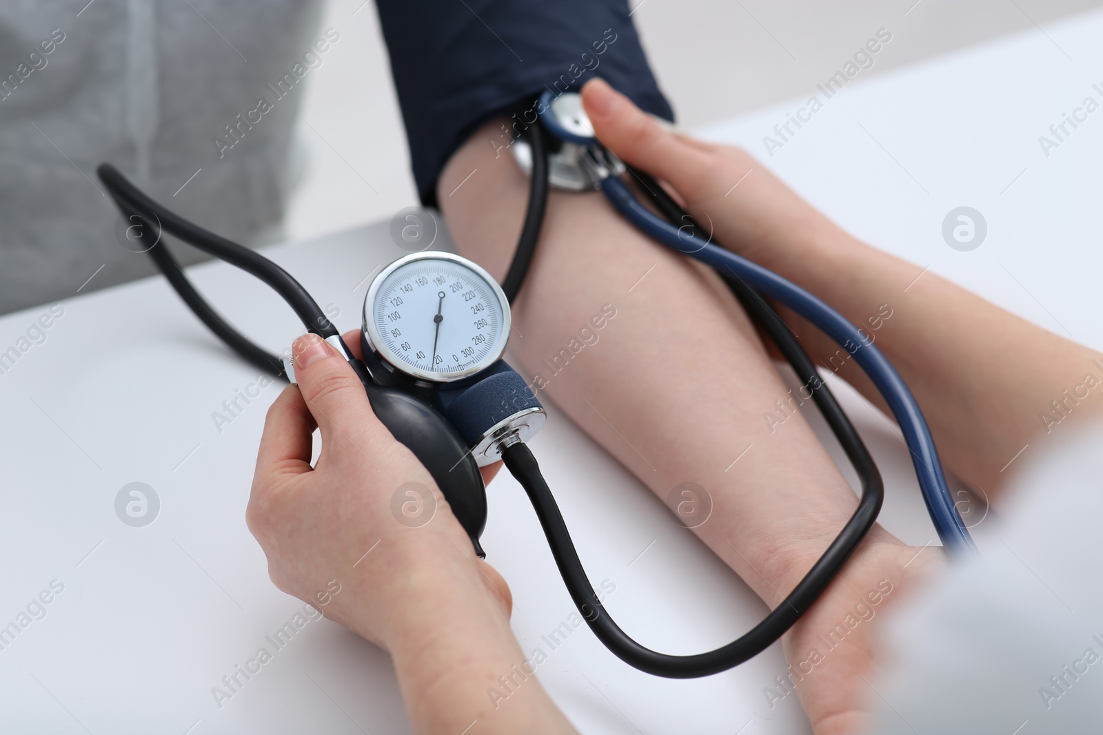 Photo of Doctor checking blood pressure of woman in clinic, closeup