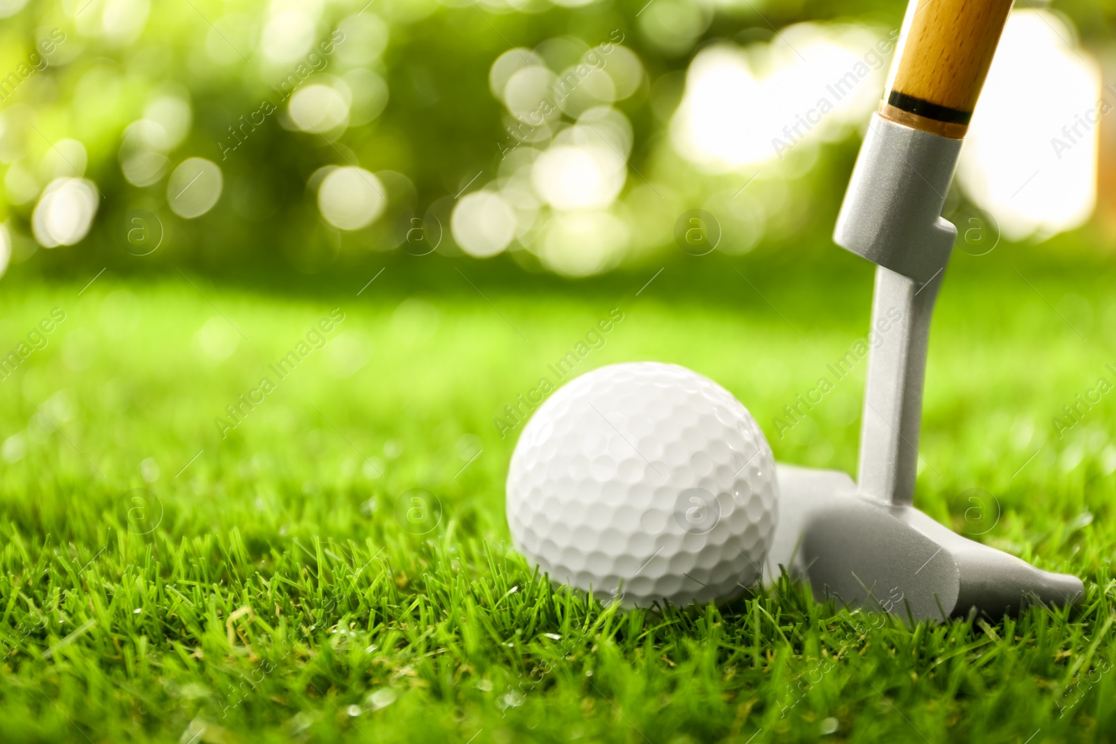 Photo of Hitting golf ball with club on green course