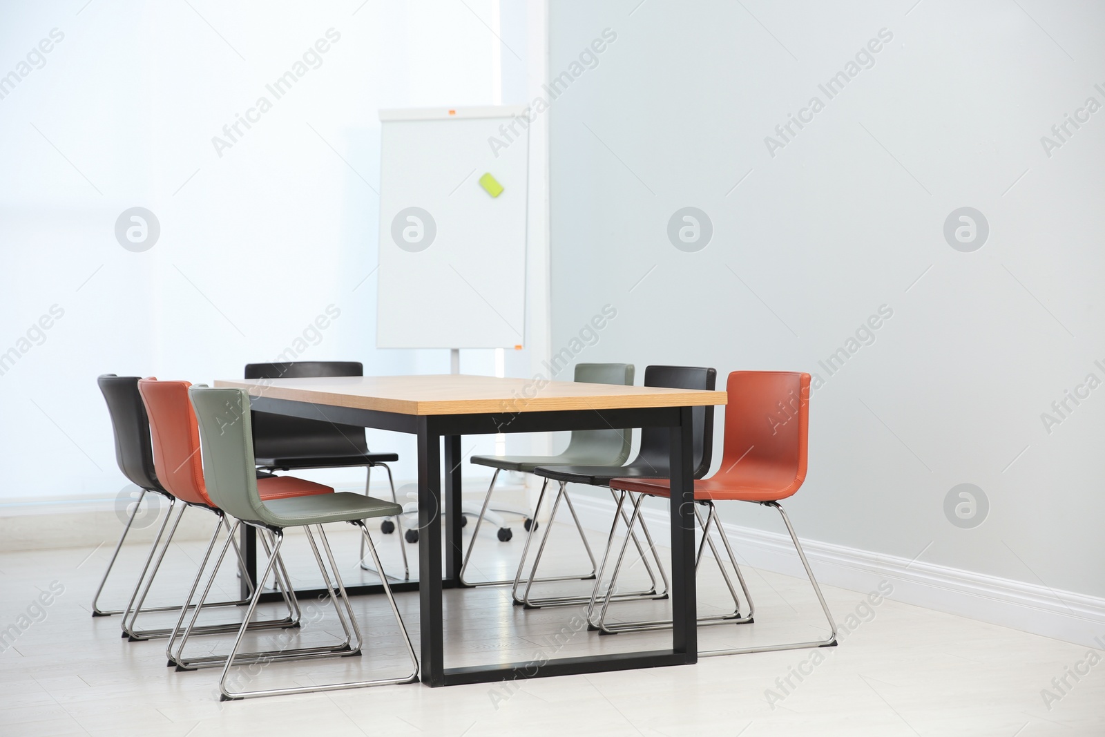 Photo of Conference room interior with wooden table and flipchart