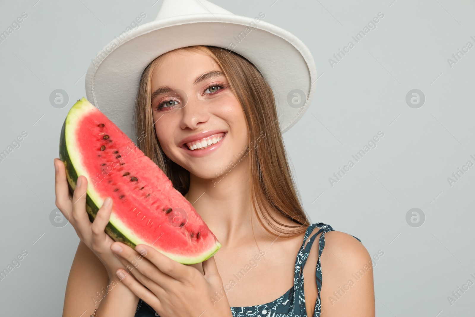 Photo of Beautiful girl with watermelon on grey background