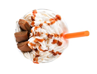 Photo of Glass of delicious milk shake with whipped cream and caramel candies on white background, top view