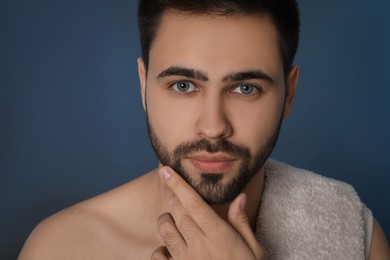 Photo of Handsome young man with beard after shaving on blue background, closeup