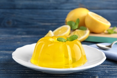 Photo of Plate with lemon jelly and mint on blue wooden table