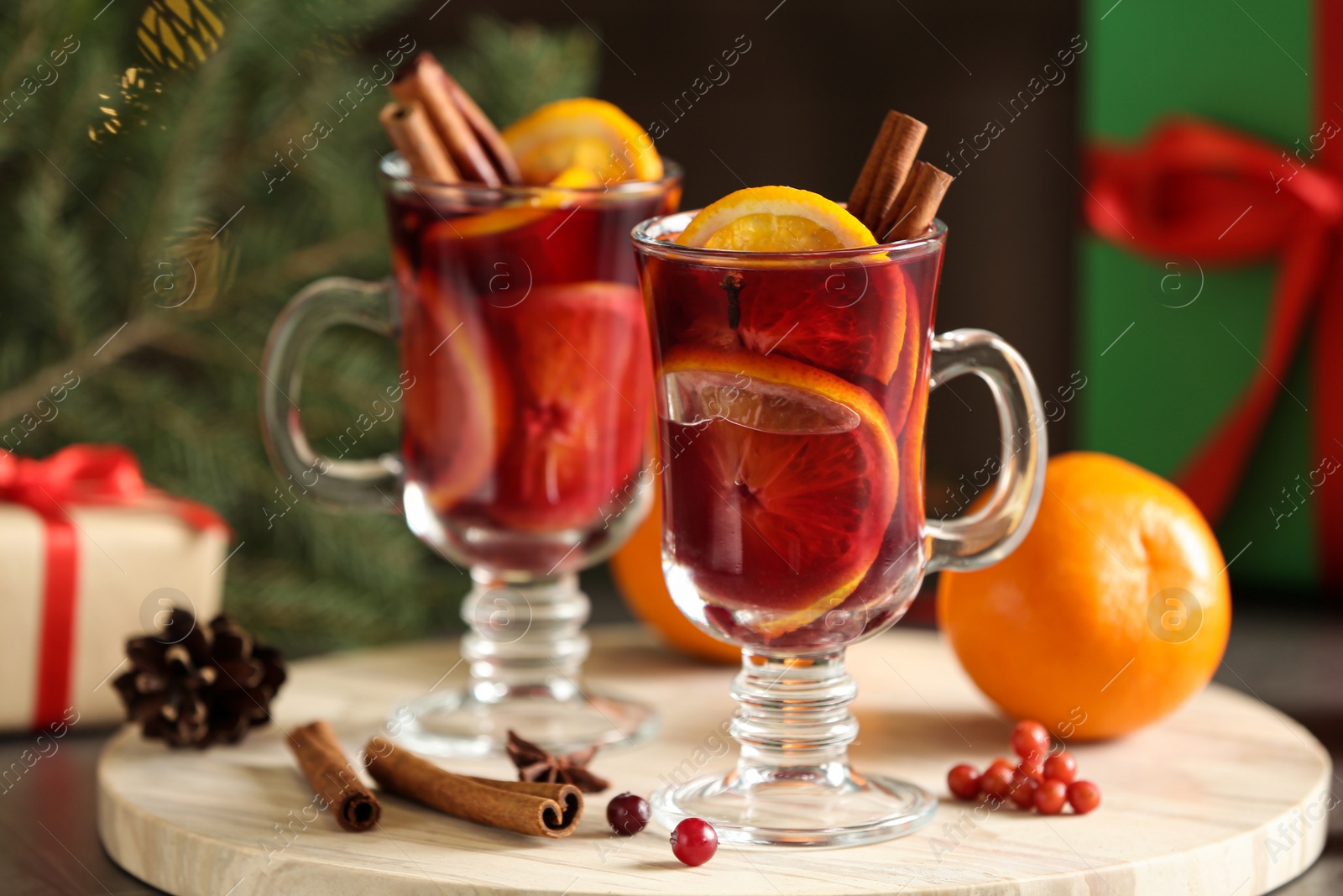 Photo of Marble board with glass cups of mulled wine on table