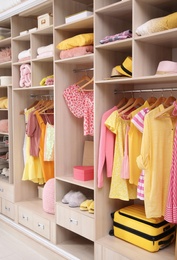 Stylish clothes, shoes and accessories in large wardrobe closet