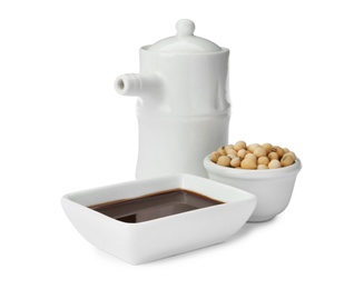 Photo of Tableware with soy sauce and beans on white background