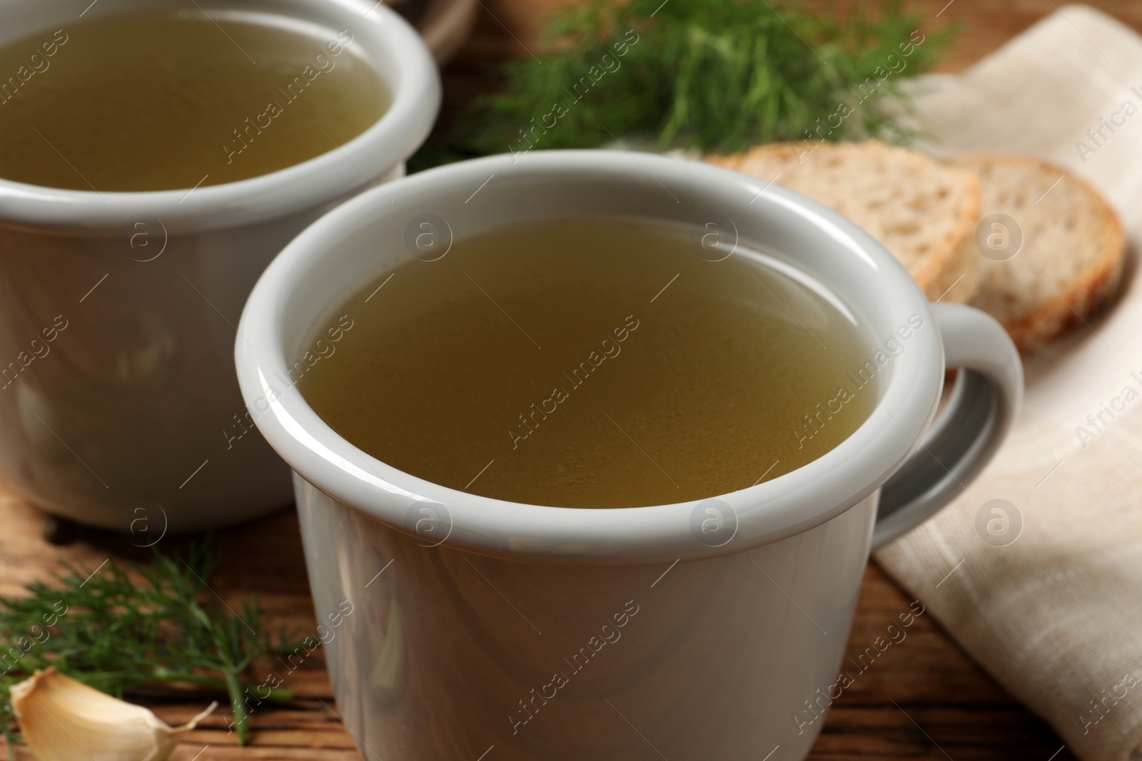 Photo of Hot delicious bouillon in cups on table, closeup